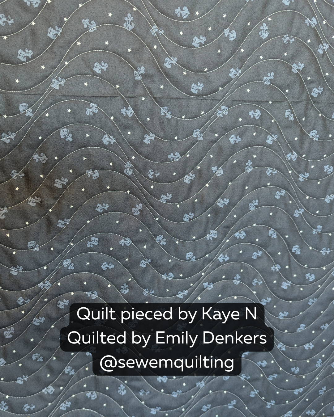 Drift Extended Width digital pantograph creating flowing wave quilting lines on a dark gray quilt with playful stars and character prints.