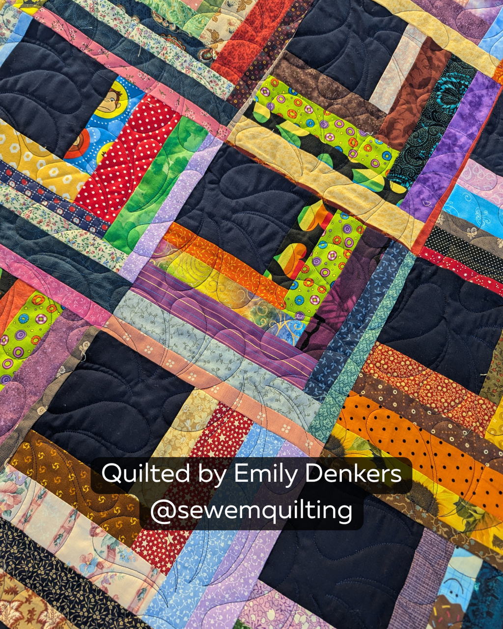 Finished colorful scrap quilt featuring the Fanned Feathers longarm quilting pattern, with graceful feathered fans adding soft edge-to-edge texture.