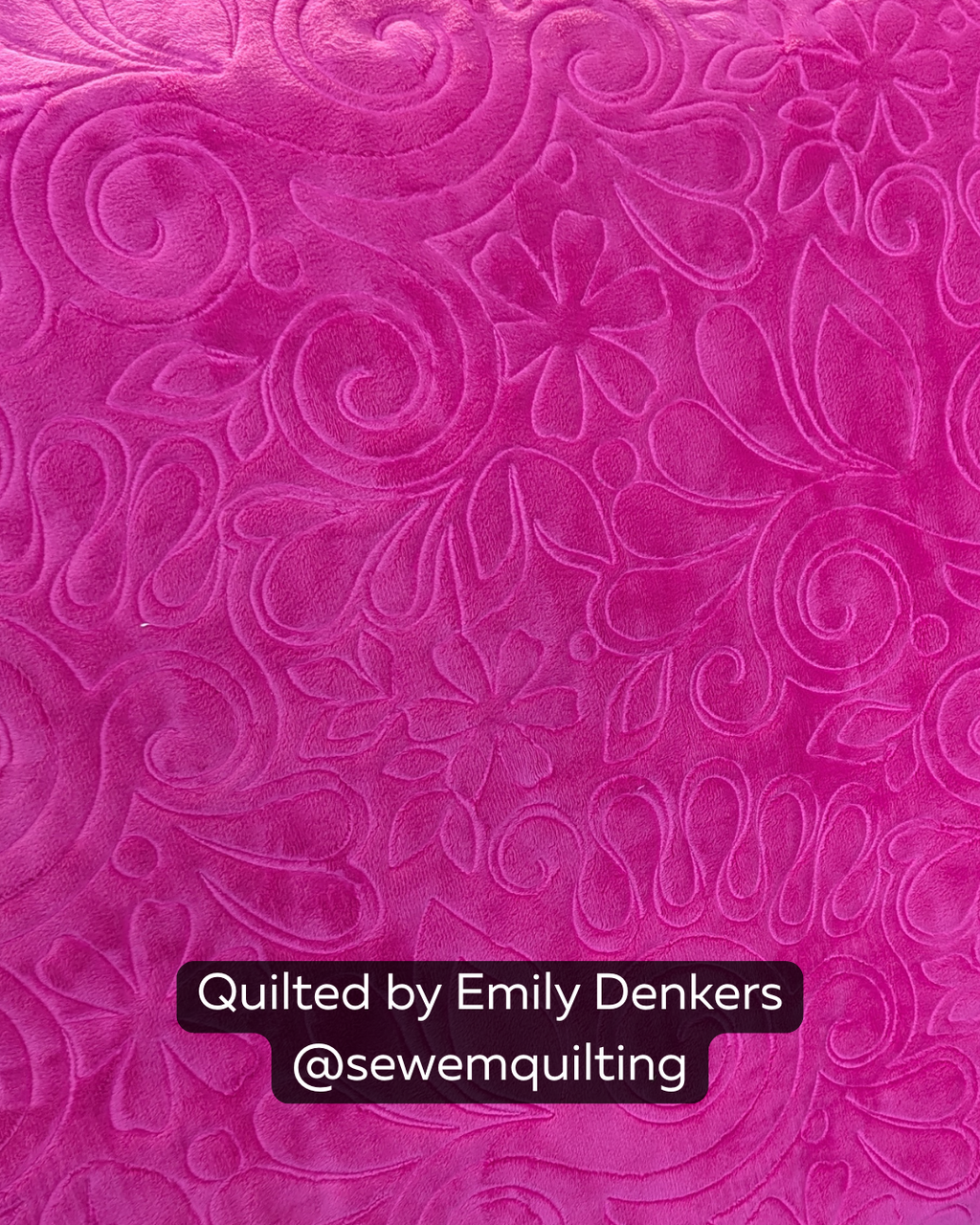 Close-up of a bright pink quilt featuring the Jungle Swirls quilting pantograph, with tropical spirals, curling vines, and flowing organic shapes stitched edge to edge.