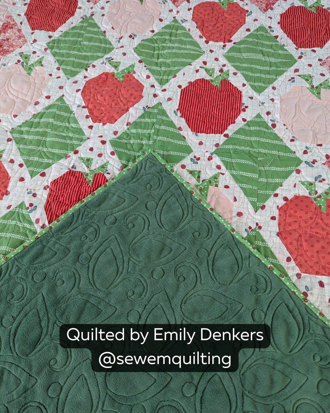 Finished strawberry patchwork quilt featuring the Leaf and Tendril quilting pantograph, with flowing leaves and curling tendrils stitched edge to edge.