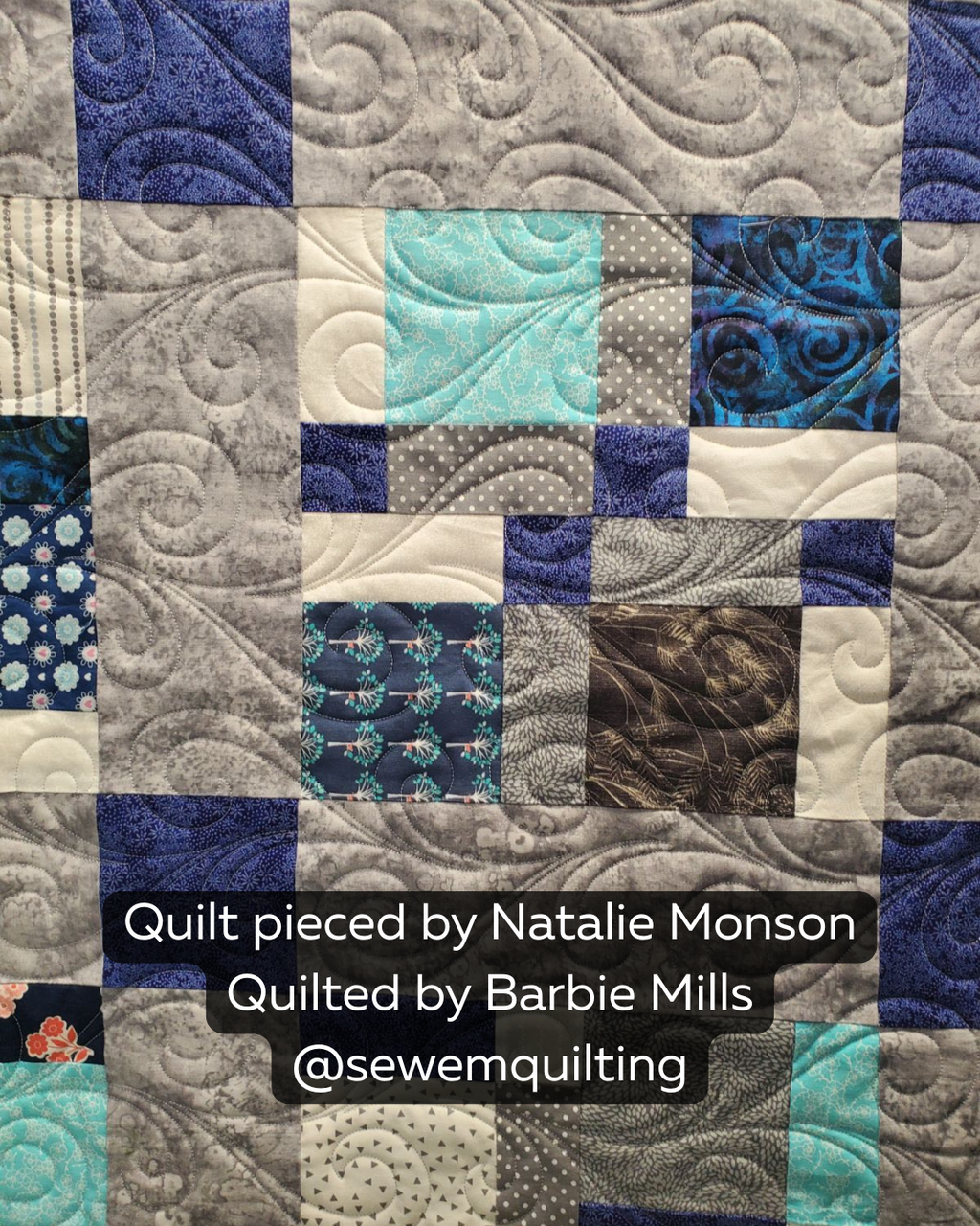 Finished blue, aqua and gray patchwork quilt featuring the Misty Swirl digital quilting pantograph with soft flowing curves