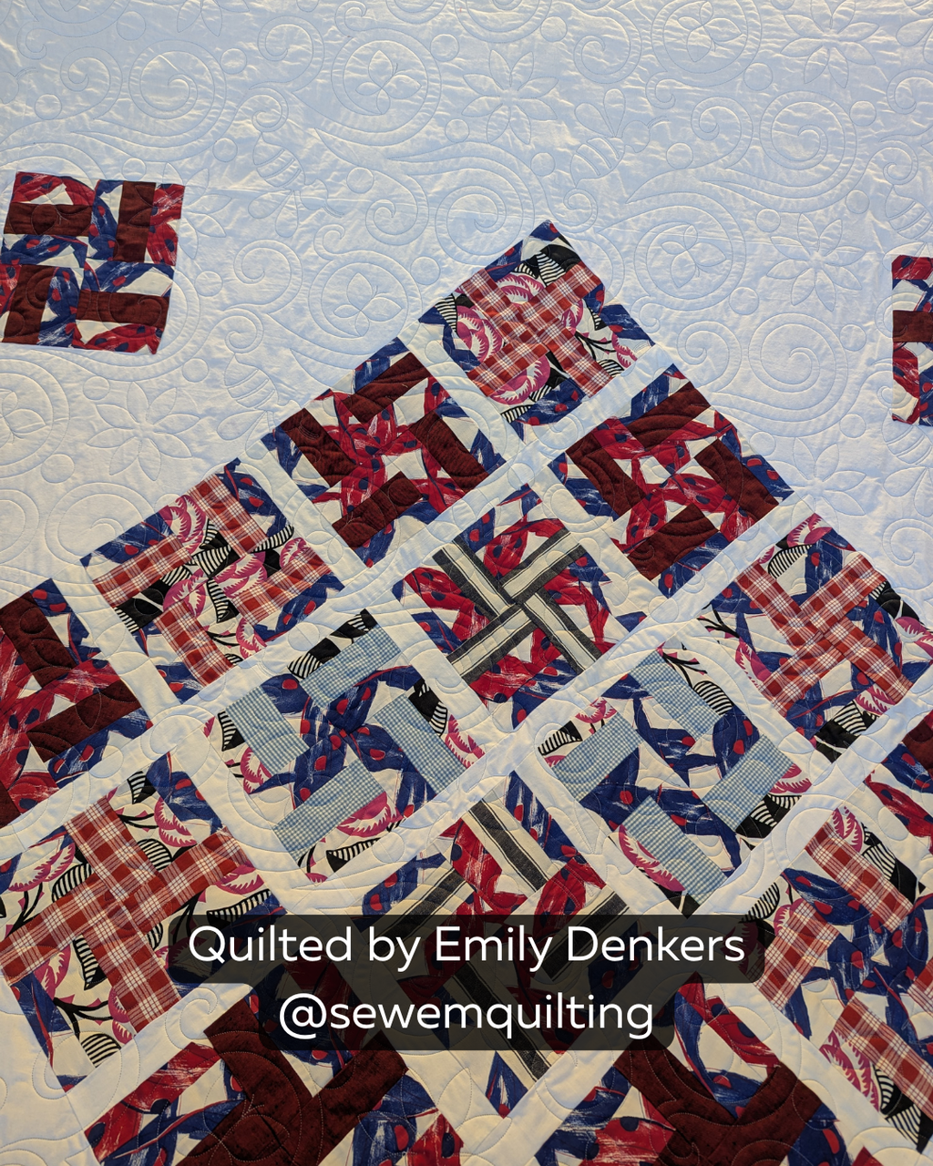 Finished red, blue and white patchwork quilt featuring the Spring Dreams quilting pantograph, with whimsical flowers, butterflies, bees and swirling lines stitched edge to edge.