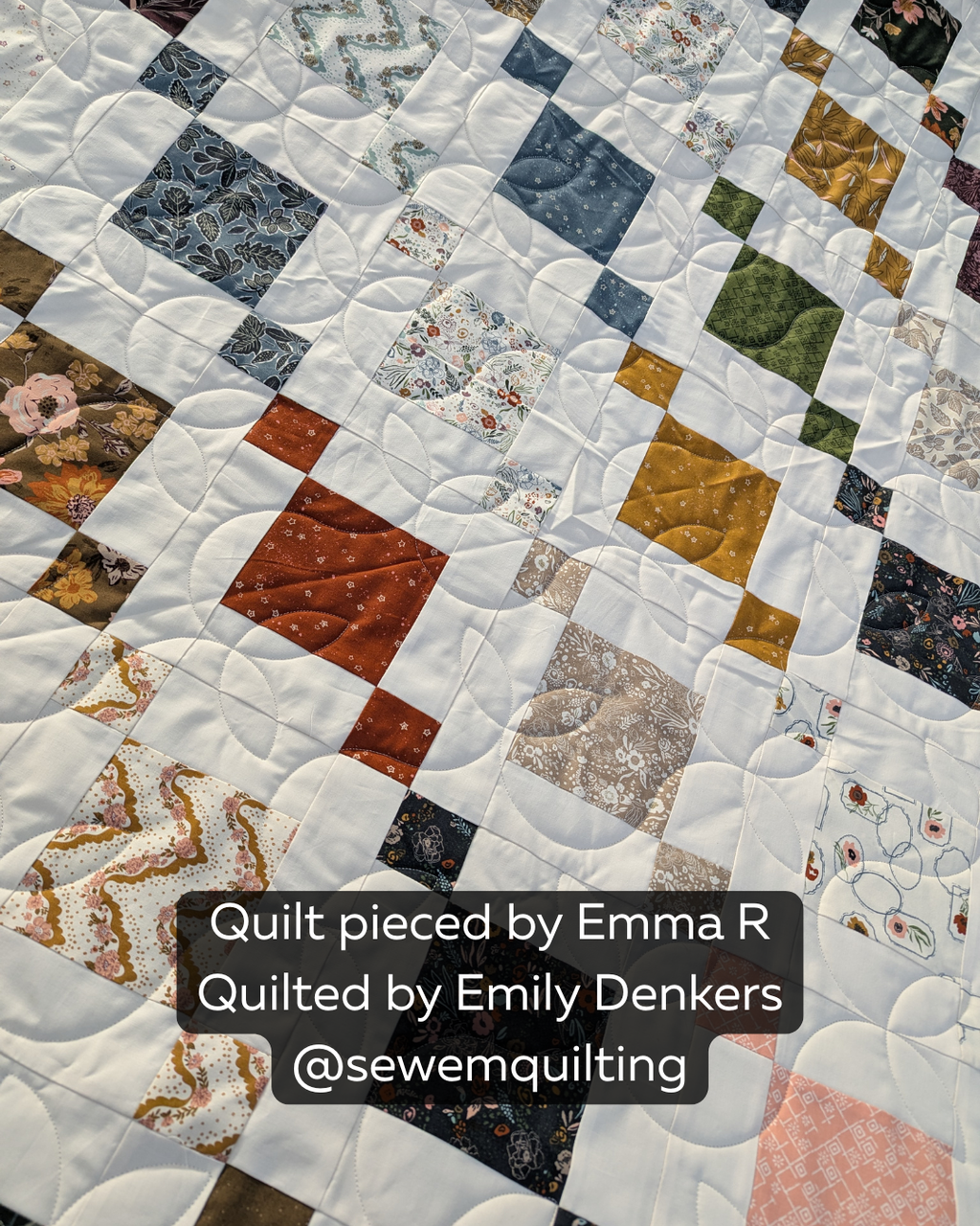 Sprouting digital pantograph with flowing leafy curves on a white and multicolored geometric quilt