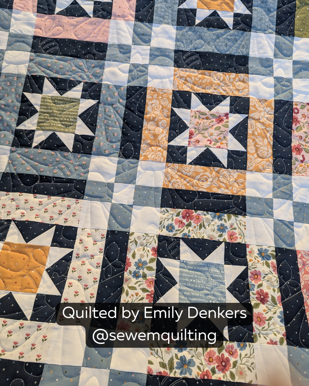 Finished blue, navy, white and golden patchwork quilt featuring the Summer Coneflowers Simple quilting pantograph, with cheerful floral petals stitched edge to edge.