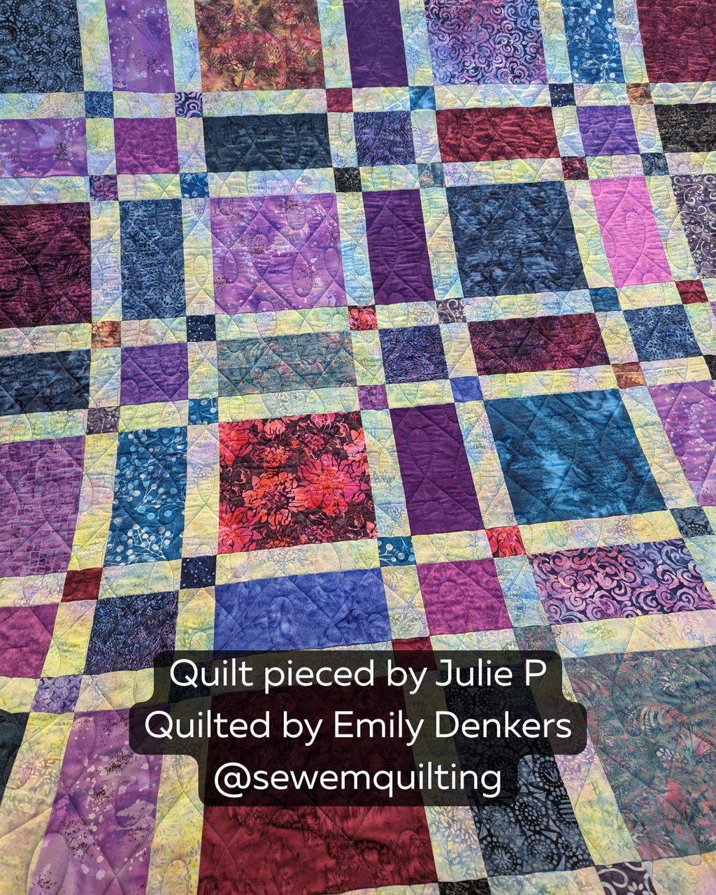 Colorful patchwork quilt featuring the Uneven Wishbone Loop pantograph, with elegant looping stitches adding texture to a vibrant batik fabric design